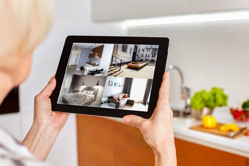 Cropped view of grey hair woman using modern tablet to view a property